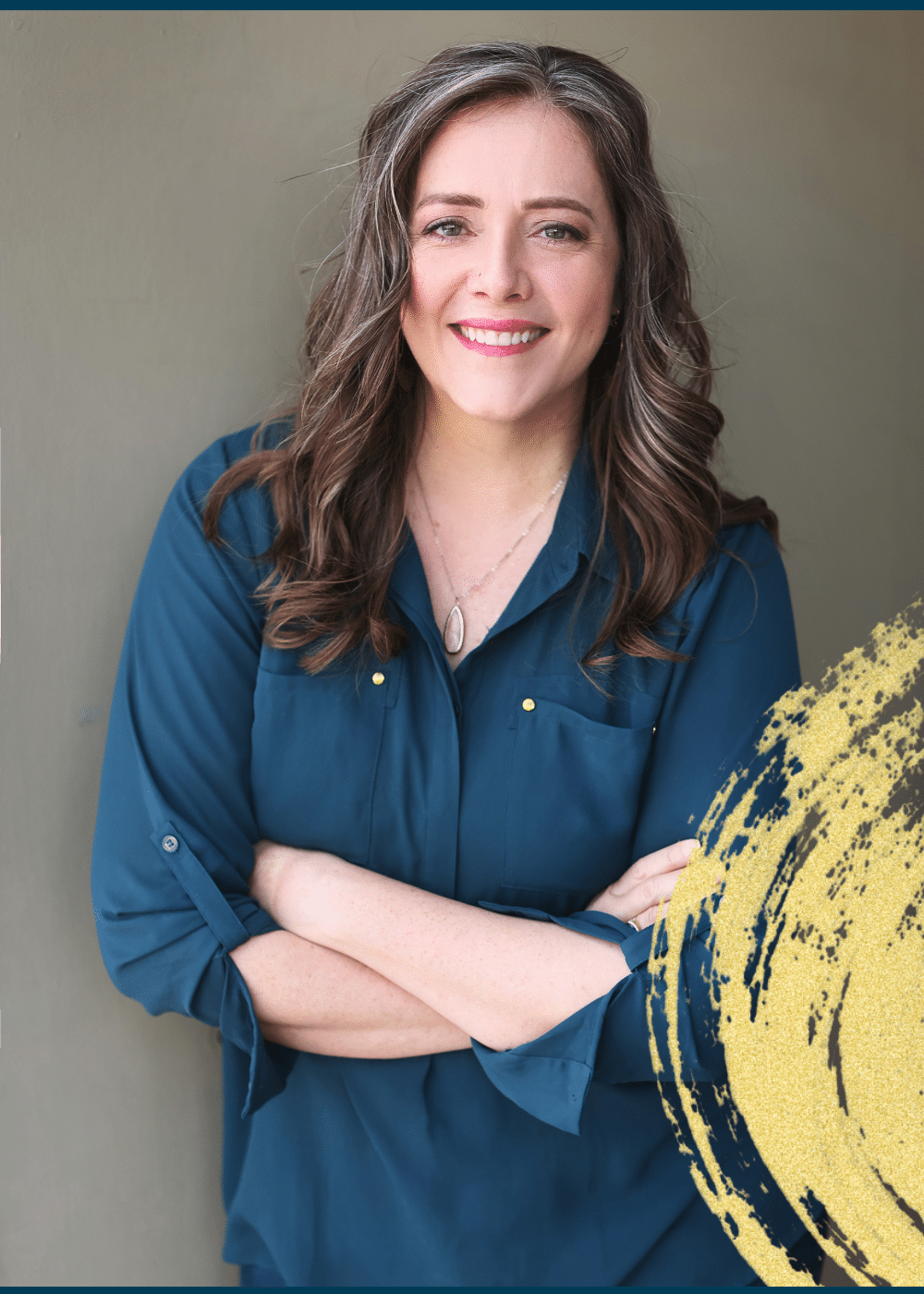 Angella Johnson smiling wearing teal shirt with arms folded in front of her standing in front of a beige background